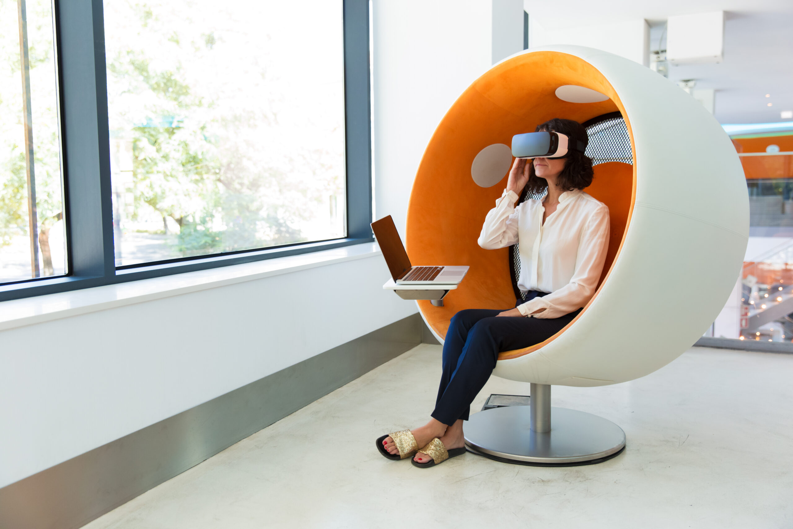 woman sitting in orange pod seat wearing virtual reality headshot