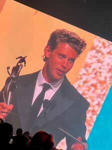 actor Austin Butler accepting an award on stage at the vanguard awards in palm springs, california