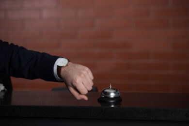 cropped shot of businessman looking at watch while waiting for service at hotel reception desk