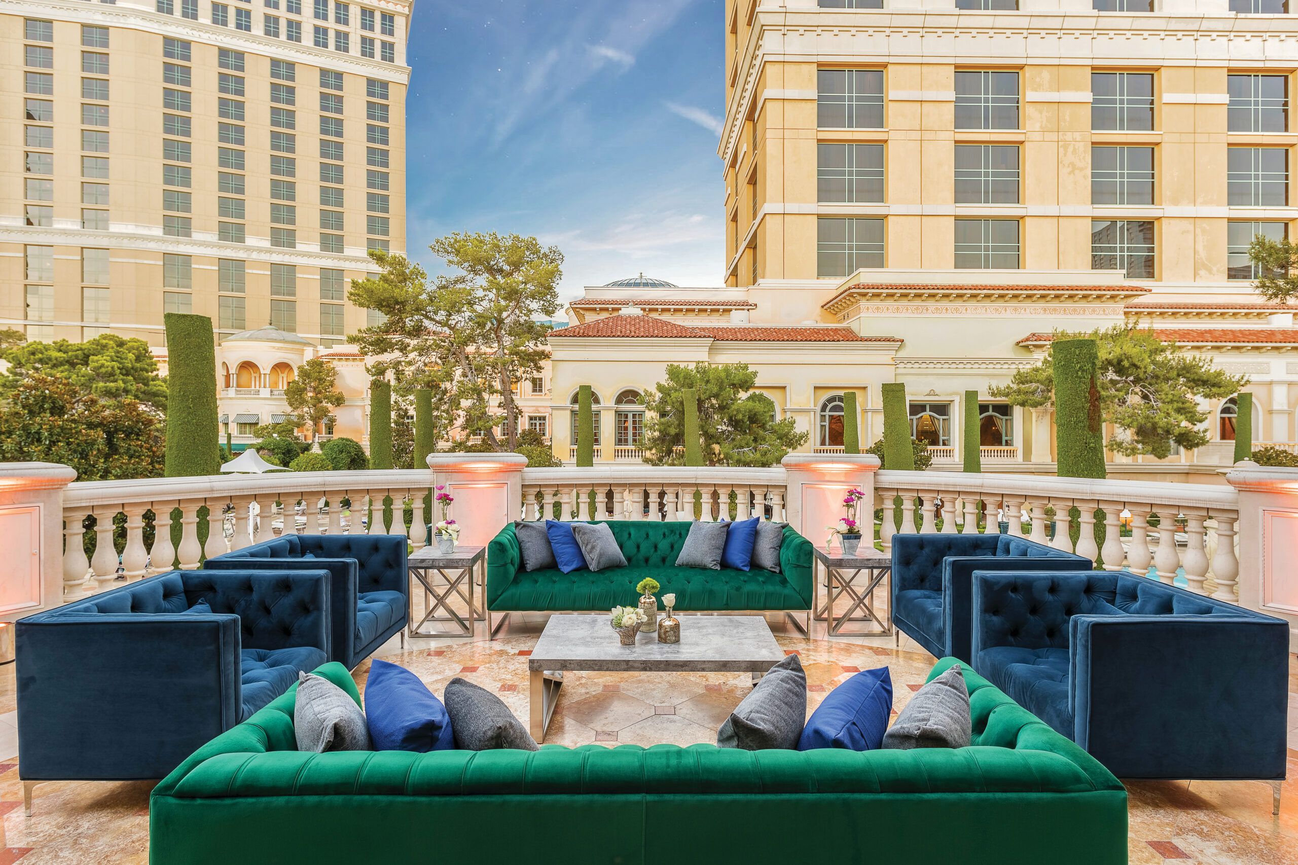 An outdoor patio at Mandalay Bay Beach. Blue and green couches are arranged around a small table.