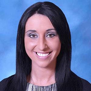 A portrait of Emily Scheiderer. She is a white woman with straight black hair and a black jacket