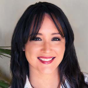 A portrait of Laurae Clifford. She is a woman with black braids and a collared shirt