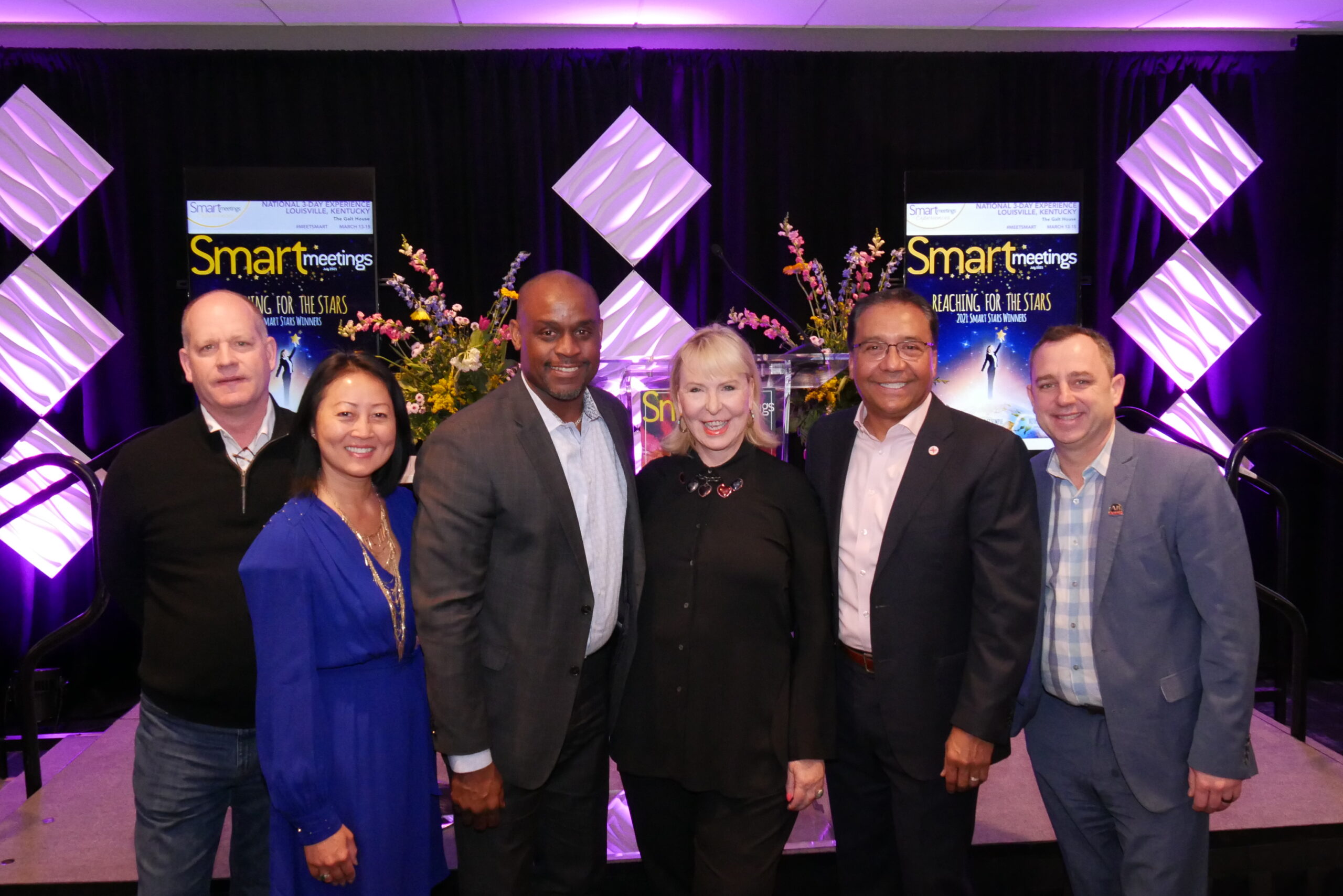 A group of Smart Meetings event attendees posing for a picture with Marin Bright