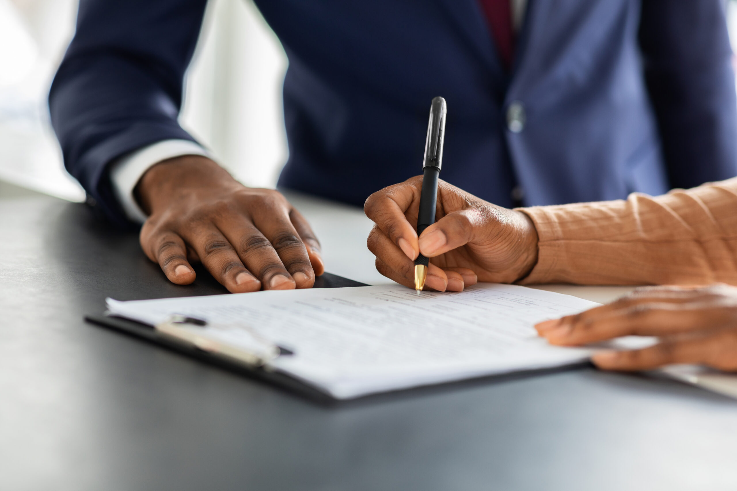 Two people signing a contract. If circumstances change, the contract can include a force majeure clause