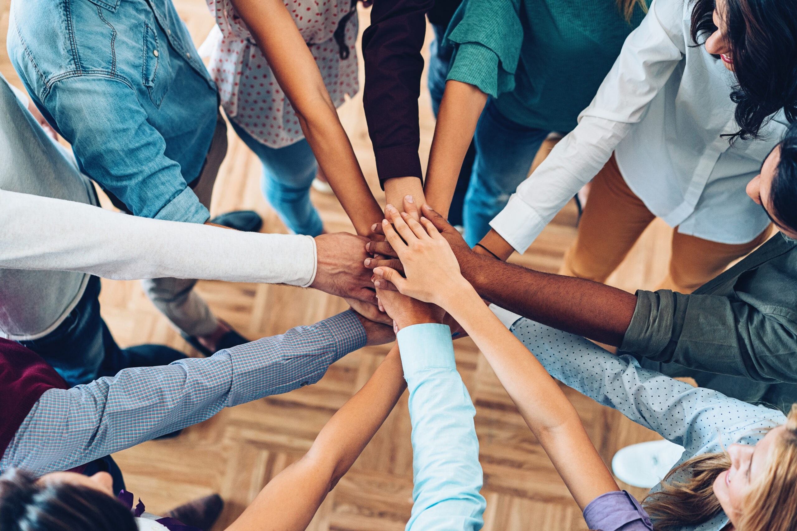 A group of business people putting their hands in a circle during a business event