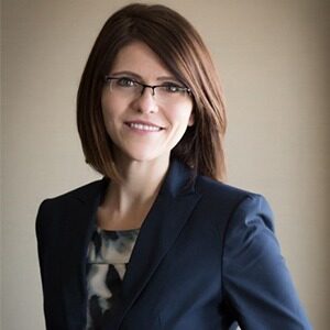 A portrait of Tammy LeBlanc. She is a younger white woman with shoulder-length brown hair and thin glasses. 