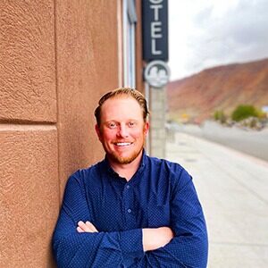 A portrait of Colton Call. He is a white, red-haired man with a blue collared shirt.