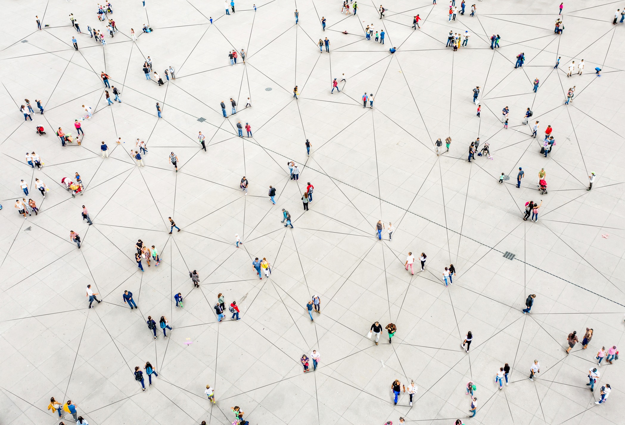 Many people spread out on pavement with digital lines connecting them.