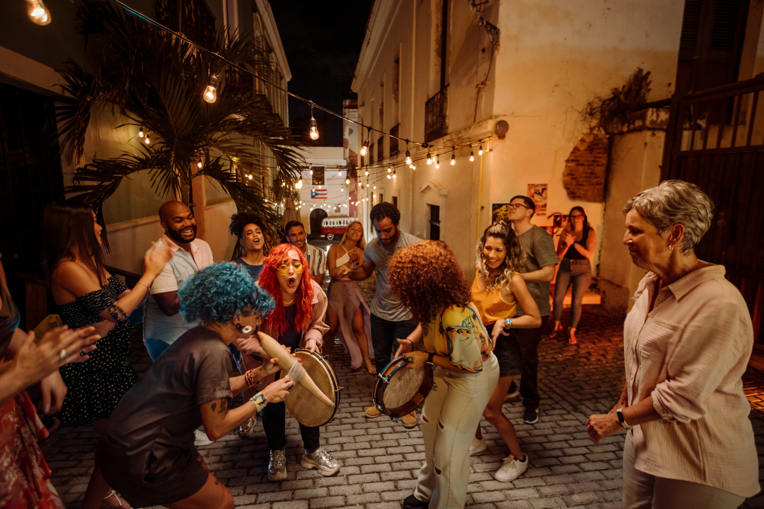 multiple people dancing, singing and playing instruments in an alley in puerto rico