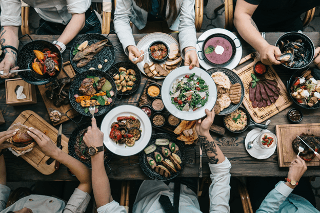 six people dining at table and passing food around