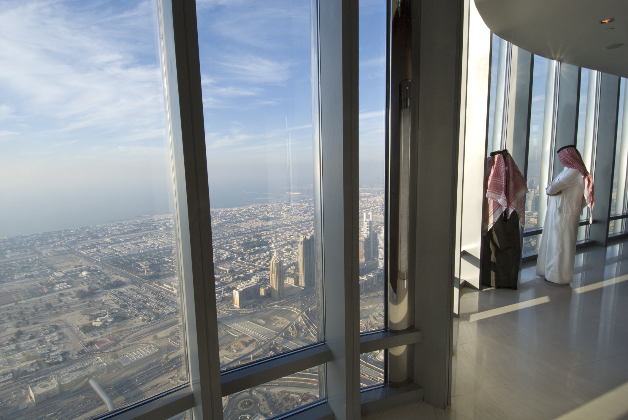 two men looking at dubai from the burj khalifa