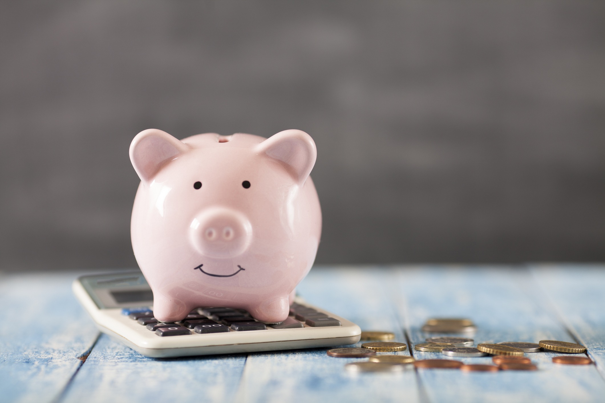 pink piggy bank sitting on top of calculator