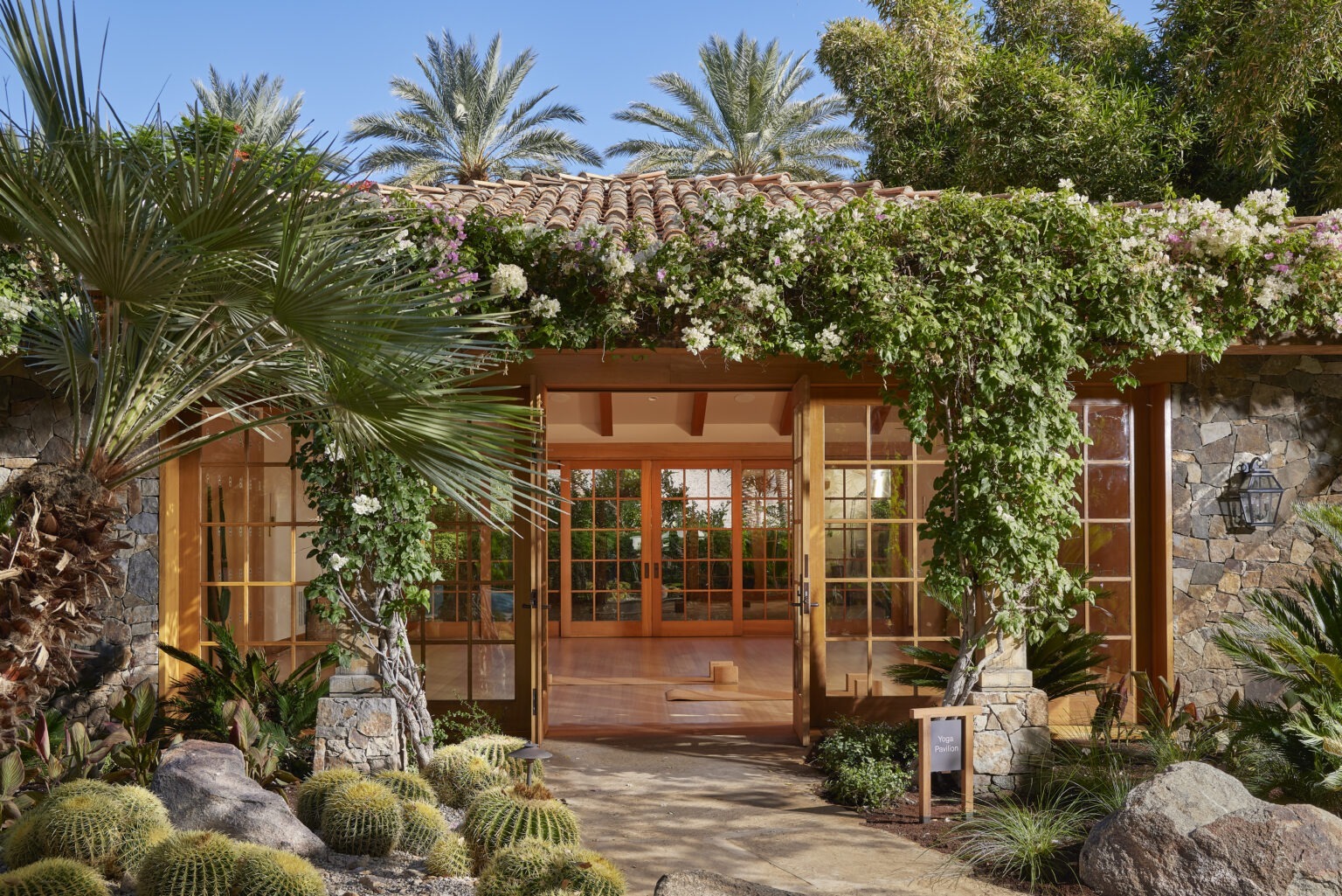 stone entrance with flower-draped trellis