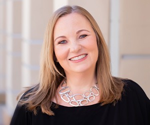 headshot of kristin mcgrath wearing black top and silver necklace