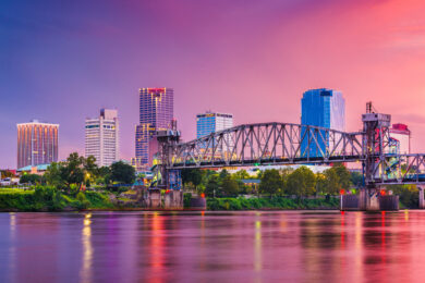 skyline and bridge over river at twilight in little rock, arkansas