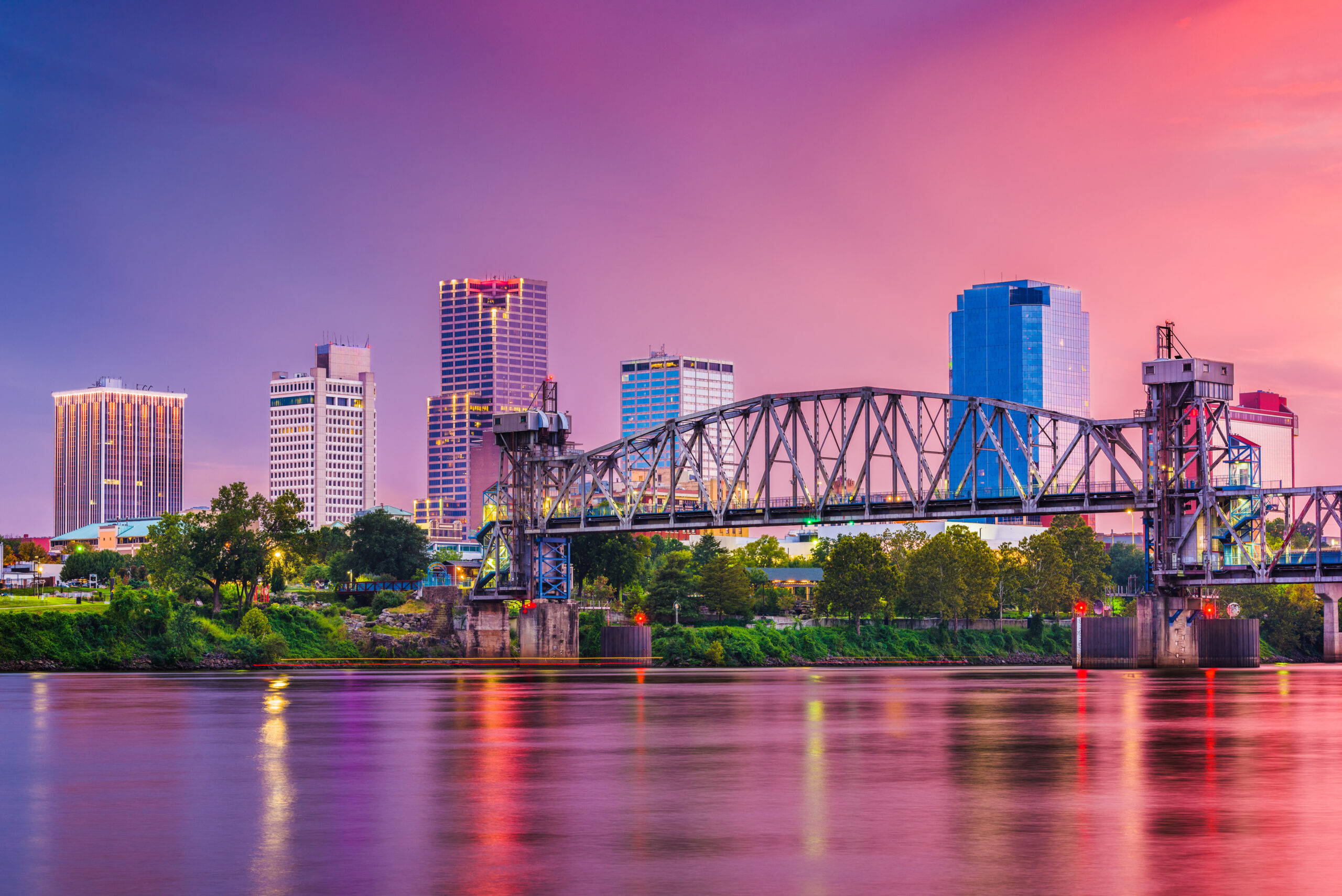 skyline and bridge over river at twilight in little rock, arkansas