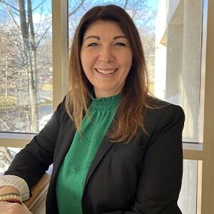 candy iannucci-guay wearing green silky top and black blazer