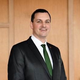 ian ring wearing white dress shirt, green tie and black sport coat