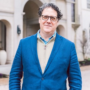 Jordi Vallѐs Blistin wearing blue blazer and light brown jacket and blue dress shirt under