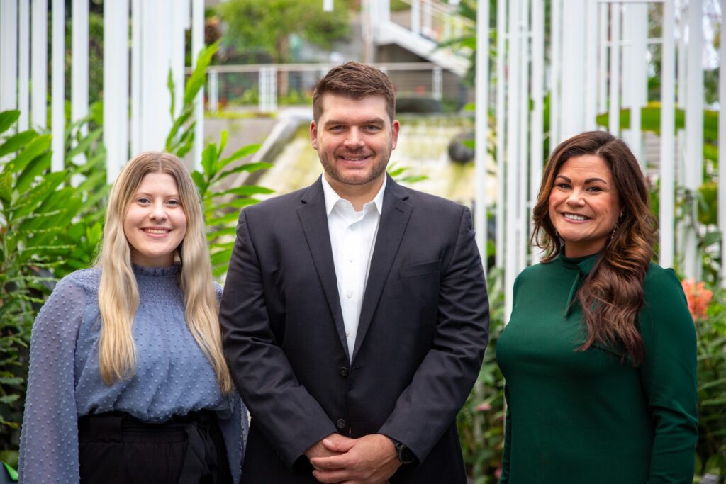 Liv Cowan on left wearing blue top, Blake Ruggs in middle wearing black sport coat and white dress shirt, and Lesley Patterson wearing green top