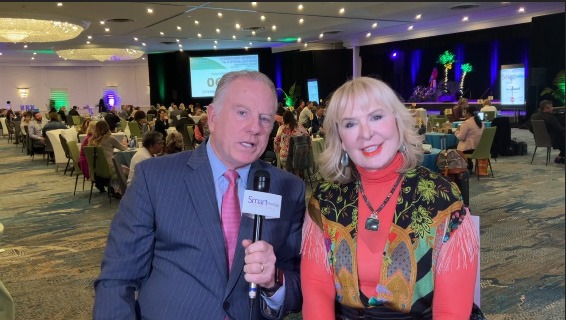 mike lyons wearing blue suit and marin bright wearing colorful orange shirt and multicolored shawl