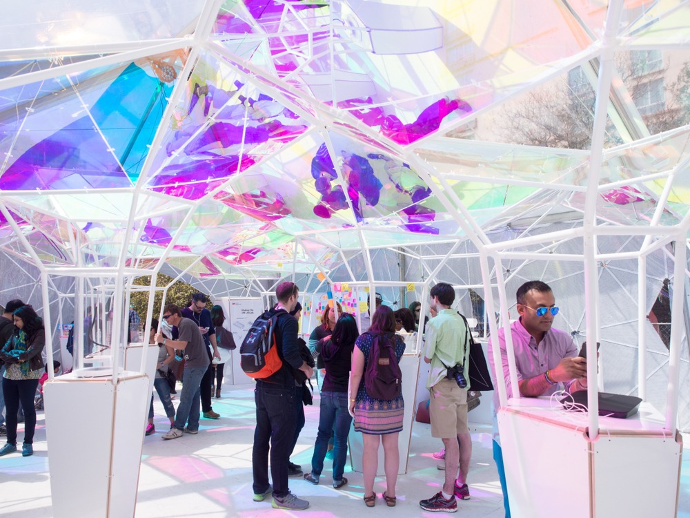 people at purple and white booth at South By Southwest