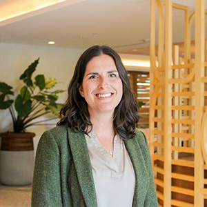 woman wearing green coat and light brown dress shirt