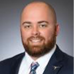 man smiling, wearing blue sport coat and white dress shirt