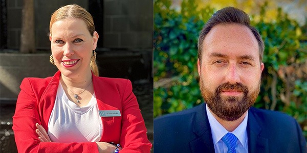 woman on left wearing red sport coat and white dress shirt and man on right wearing blue dress coat and white dress shirt