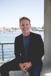man wearing black sport coat and blue shirt