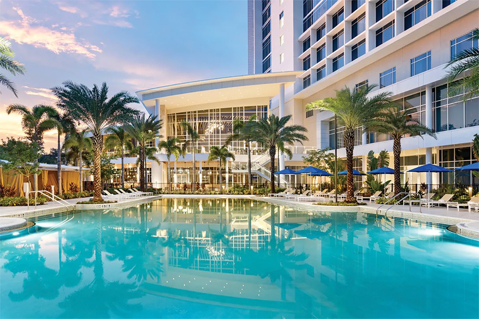 hotel pool surrounded by palm trees