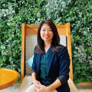 woman sitting, wearing blue sport coat and blue dress shirt