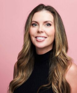 woman wearing black sleeveless shirt in front of pink background
