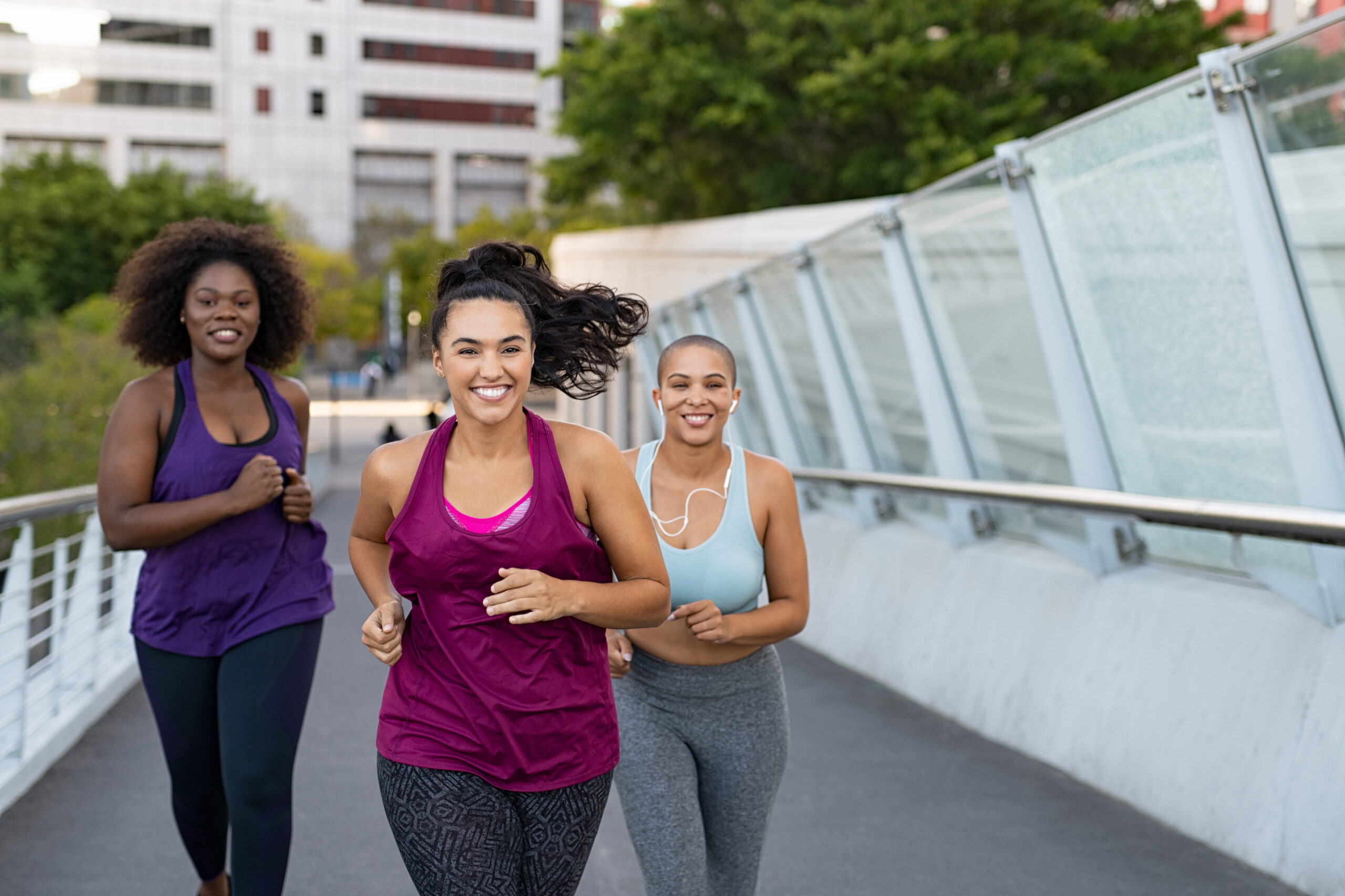 three woman running across pathway
