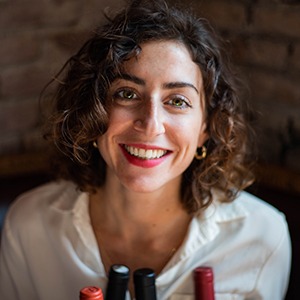 A woman in a white shirt smiles into the camera