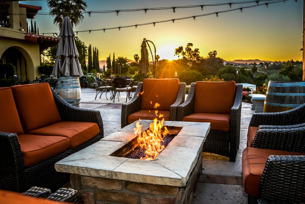 seats around a fireplace at sunset