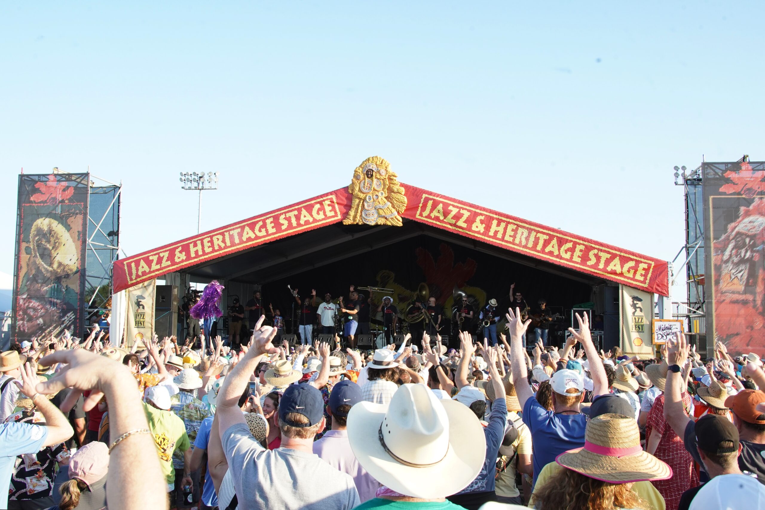 large crowd standing in front of music stage