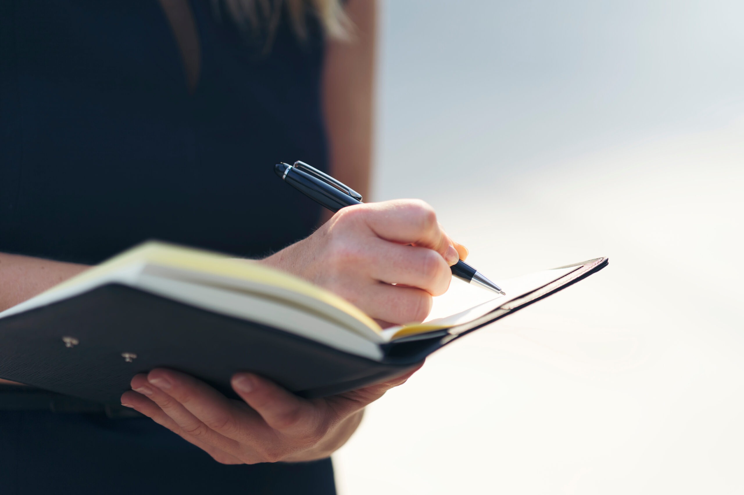 Businesswoman writing in notebook