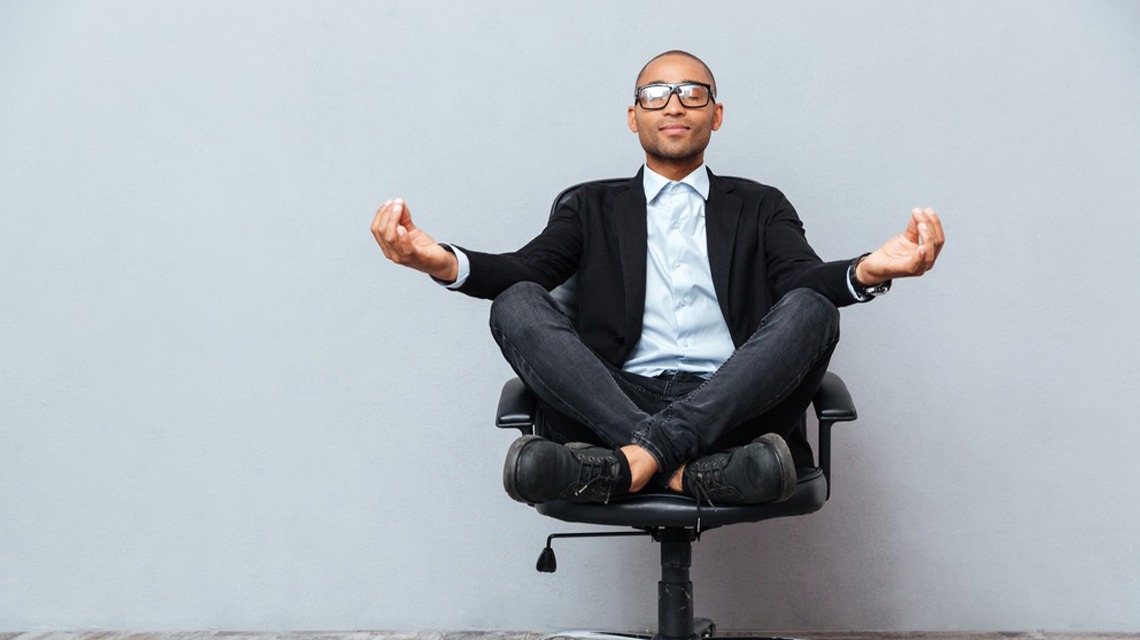 man sitting and meditating on office chair