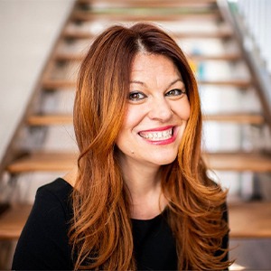 woman smiling, wearing black long sleeved shirt