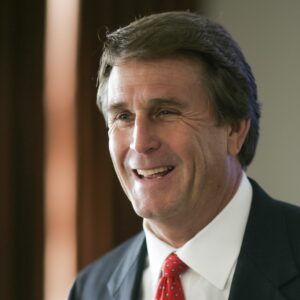 man in black suit smiling