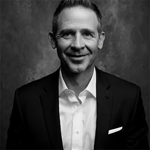 black and white photo of man in dress shirt and sport coat