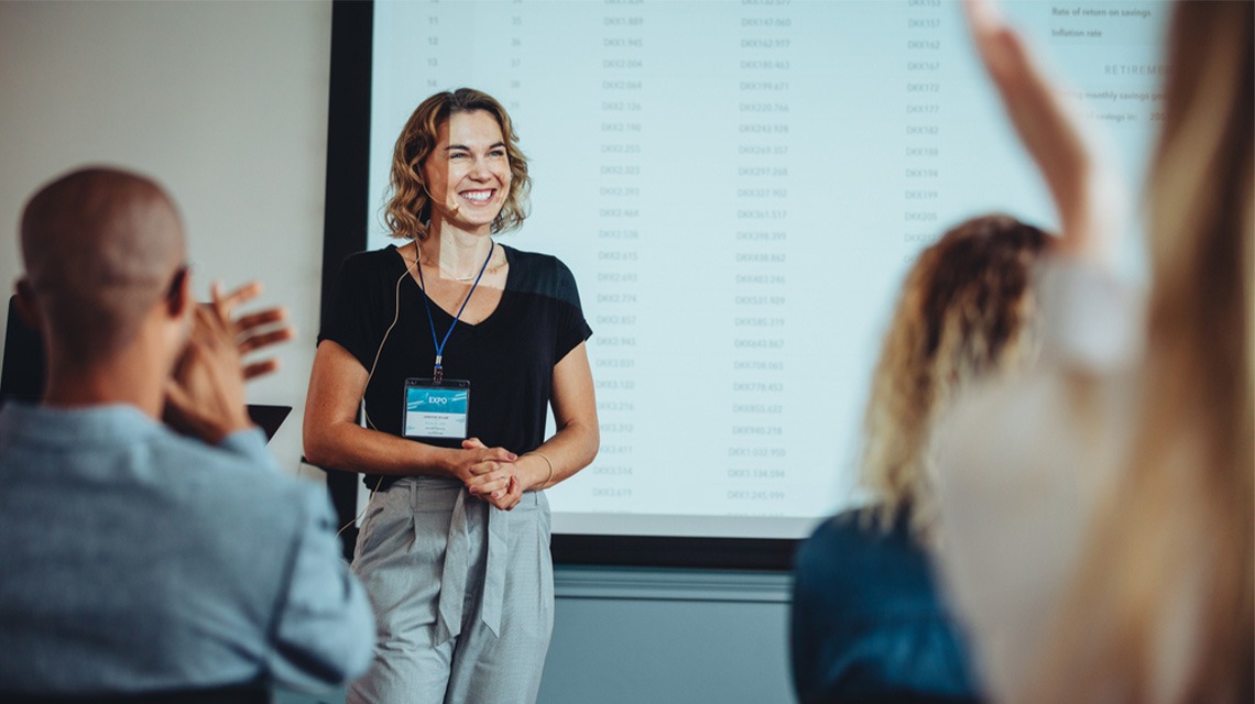 Team of professionals clapping hands in a meeting for a female presenter