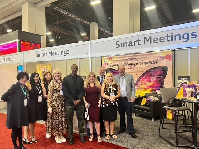Smart Meetings team of 7 people in front of booth