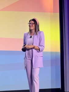 woman in light purple suit talking on stage
