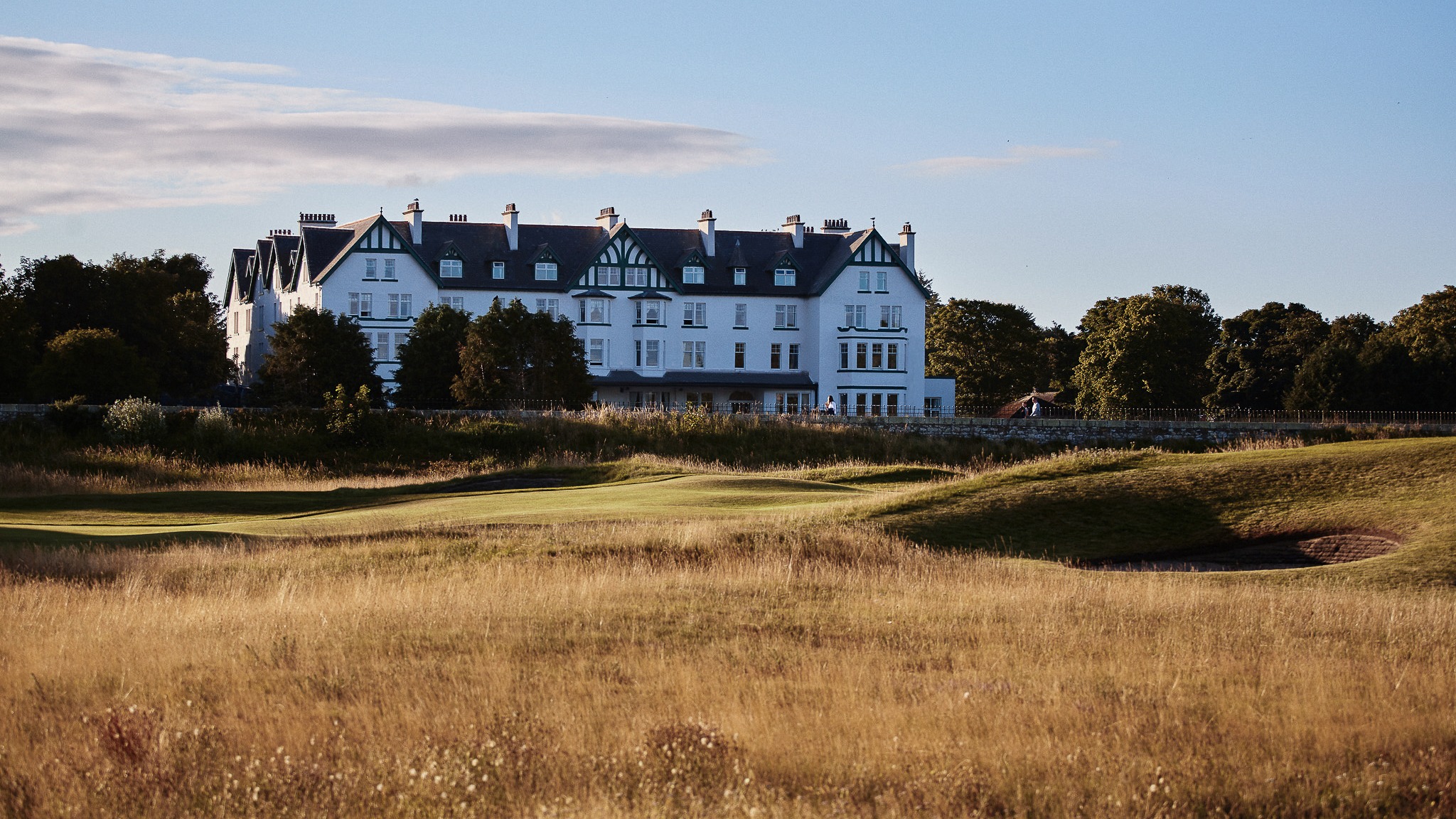 Exterior image of Dornoch Station in Scotland behind a field and golf course