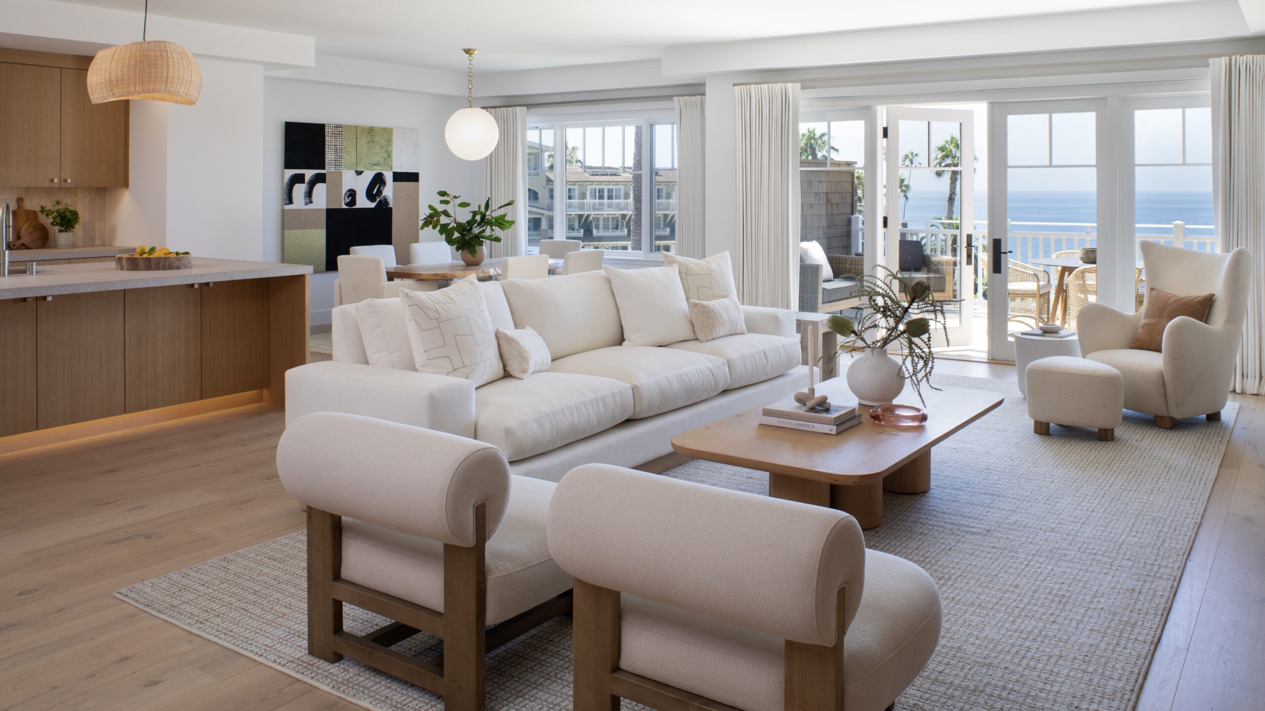 The living room with a view of the kitchen at new and renovated Villa Le Ciel at Montage Laguna Beach