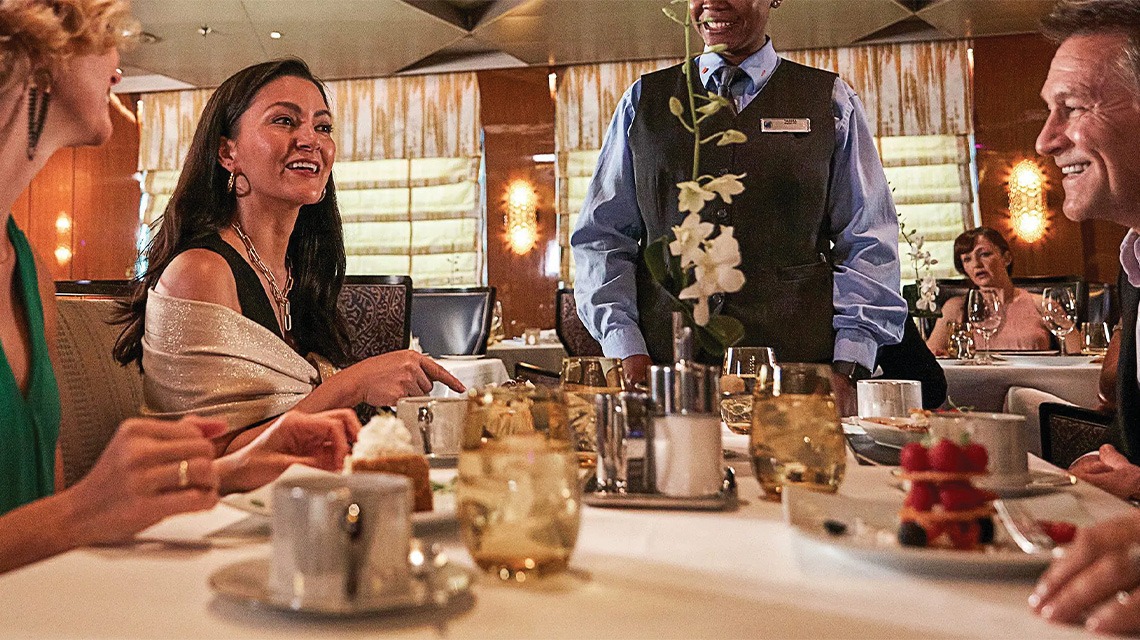 three people smiling and eating food