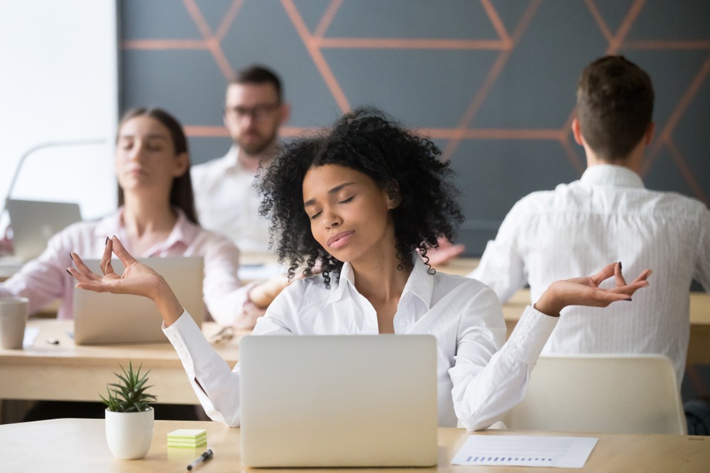 four businesspeople closing their eyes and relaxing