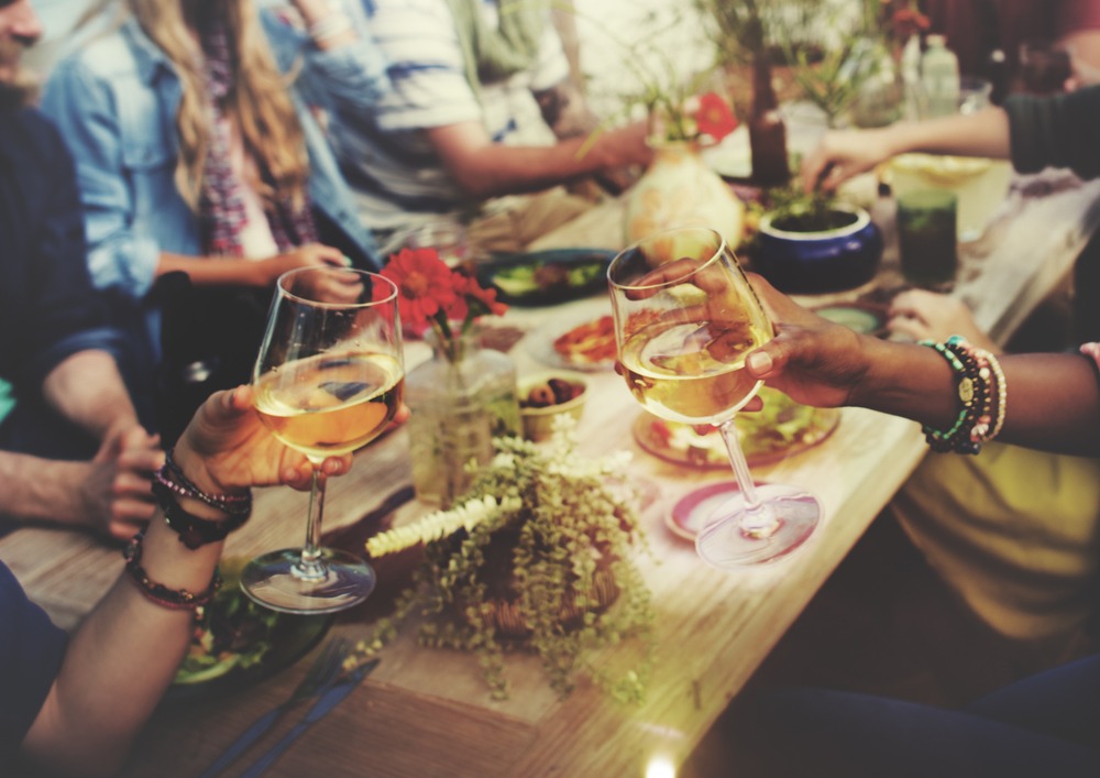 people clinking wine glasses